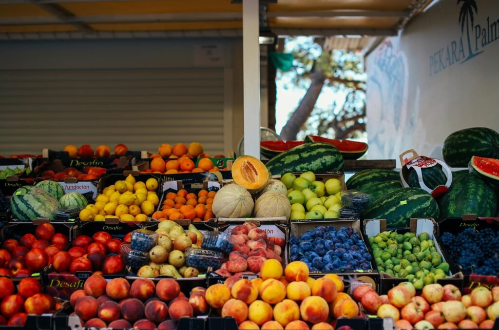 Vibrant variety of fresh fruits at an outdoor stand, perfect for a healthy diet.