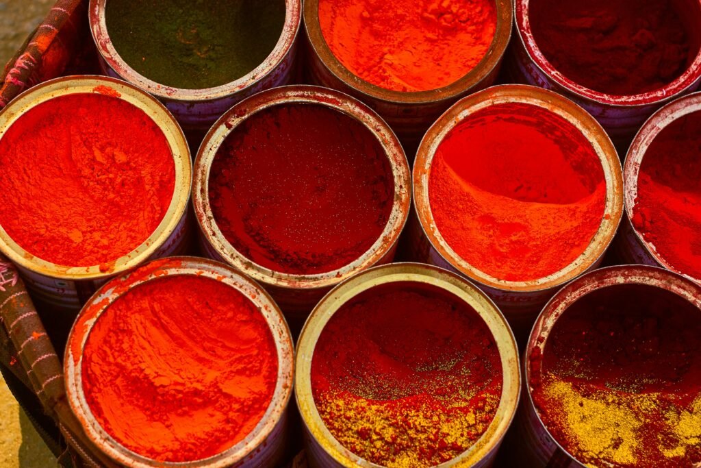 A colorful assortment of spices in buckets, showcasing vibrant red hues.
